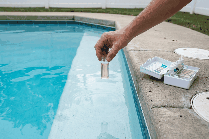 Testing pool water for free chlorine with a drop test kit at the pool edge